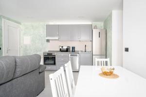 eine Küche und ein Wohnzimmer mit einem Tisch und einem Sofa in der Unterkunft Alojamiento Barco de Valdeorras in Vegamolinos