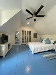 a white bedroom with a bed and a ceiling fan at The Paddock House at Blanco Texas in Blanco