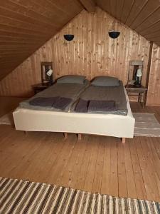 a bedroom with a bed in a wooden room at Majatalo Wanha-Pirtti in Iitti