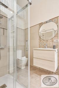 a bathroom with a shower and a toilet and a mirror at La Linda Little Apartments in Cádiz