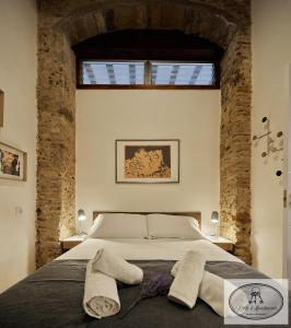 a bedroom with a large bed with brick walls at La Linda Little Apartments in Cádiz