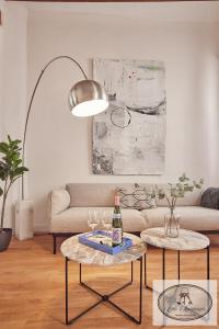 a living room with a couch and two tables with wine glasses at La Linda Little Apartments in Cádiz