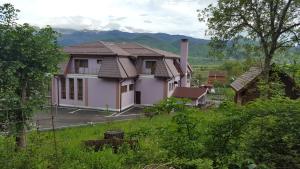 una casa con montañas en el fondo en Pensiunea Oșencuța, en Tălmaciu