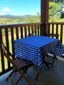 een blauw en wit geruite tafel en stoelen op een veranda bij Chalés Santa Luzia in Santo Antônio do Pinhal