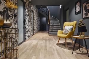 a hallway with a yellow chair and stairs at Cama Luxury Suites in Athens