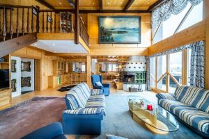 a living room with blue couches and a staircase at Heidi-Alm Lodge in Falkertsee