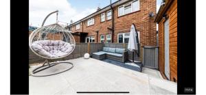 a swinging chair on a patio in front of a building at Art Deco Property in Bromley in London