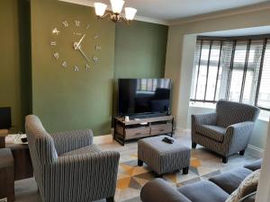 a living room with a large clock on the wall at Art Deco Property in Bromley in London