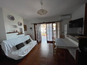 sala de estar con sofá blanco y mesa en Apartamento Siesta Mar 1 Apartamento 26 Cala en Porter, en Cala'n Porter