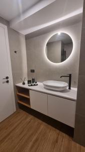 a bathroom with a white sink and a mirror at Marigold Apartments in Chania Town +20 photos