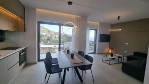 een keuken en een woonkamer met een tafel en stoelen bij Marigold Apartments in Chania