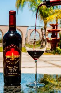 Una botella de vino está siendo vertida en una copa en Villas Persas by Jardin de Persia, en Valle de Guadalupe