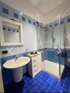 y baño de azulejos azules con lavabo y ducha. en Residenza Città Antica, en Verona