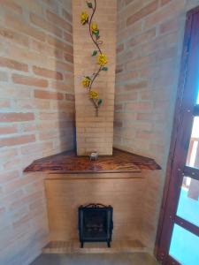 Una chimenea en una habitación con una pared de ladrillo en Chalés Santa Luzia, en Santo Antônio do Pinhal