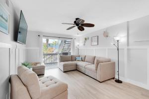 a living room with two couches and a ceiling fan at Villas on the Gulf unit C5 in Pensacola Beach