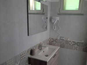 La salle de bains blanche est pourvue d'un lavabo et d'un miroir. dans l'établissement Agriturismo Farfollíe, à Pescia Romana
