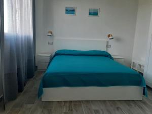 1 dormitorio con 1 cama con manta azul en Agriturismo Farfollíe, en Pescia Romana