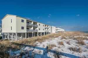a building on top of a beach near the ocean at Villas on the Gulf unit C5 in Pensacola Beach