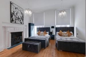 a bedroom with two beds and a couch and a fireplace at 80 by Elite in Liverpool