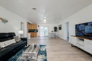 a living room with a black couch and a flat screen tv at Coastal Cove Chateau in Venice