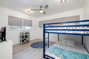 a bedroom with two bunk beds and a tv at Coastal Cove Chateau in Venice