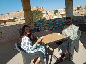 un hombre y una mujer sentados en una mesa en Neem Guest House Jaisalmer, en Jaisalmer