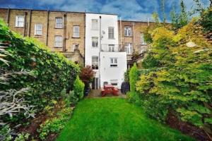 a garden in front of a large building at Beautiful Home in Camden with Garden in London