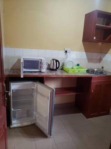 a kitchen with a counter with a microwave and a refrigerator at Appart'hotel britannia in Yaoundé