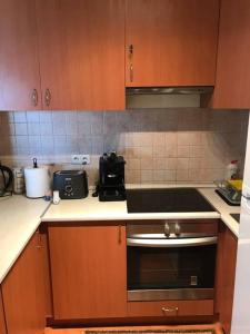 a kitchen with wooden cabinets and a stove top oven at Aréna Apartman in Budapest