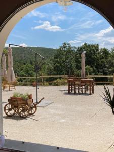 un arco con un patio con mesas y sombrillas en Agriturismo Pian del Pruno, en Santa Luce