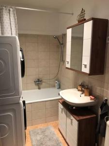 a small bathroom with a sink and a bath tub at Aréna Apartman in Budapest