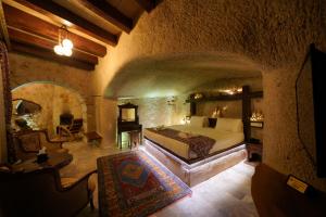 ein Schlafzimmer mit einem großen Bett in einem Steinzimmer in der Unterkunft Shoestring Cave House in Goreme