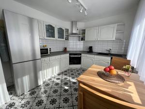 uma cozinha com armários brancos e uma mesa com frutas em Ferienhaus EifelOne em Heimbach