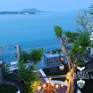 a view of the water from a house with lights at LA VILLA AURELIA in Bacoli