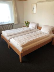 un grande letto con lenzuola e cuscini bianchi in una camera da letto di Hotel Restaurant Heidihof a Maienfeld