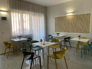 una habitación con mesas y sillas y un cuadro en la pared en Civico 49 Bed&Breakfast en Lecce