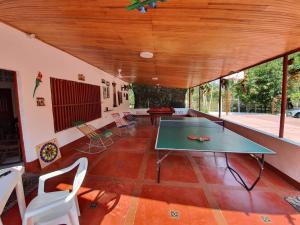 ein Zimmer mit einer Tischtennisplatte und Stühlen in der Unterkunft FINCA-CASA DE DESCANSO GUAMO TOLIMA in Guamo