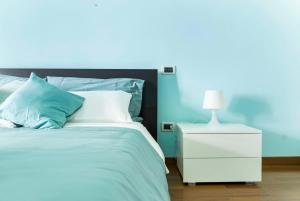a blue bedroom with a bed and a white nightstand at Light Blue House in Montesilvano