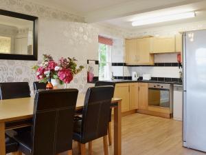 a kitchen with a wooden table and a dining room at Kennels Cottage - Beaufort Estate in Belladrum