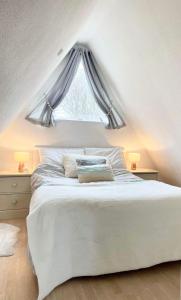 a bedroom with a white bed with a window at Chalet 95, Kingsdown Park in Deal