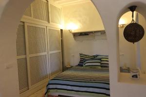 - une chambre avec un lit et deux oreillers à rayures dans l'établissement Suite Vesta Villa Naïa Domaine Béluga Bounouma Kerkennah, à Sfax