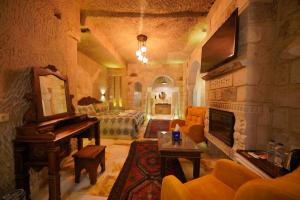 a living room with a fireplace and a piano at Shoestring Cave House in Göreme