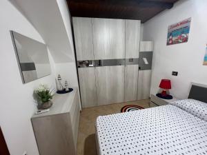 1 dormitorio con 1 cama y vestidor con espejo en Casa Murat, en Pizzo