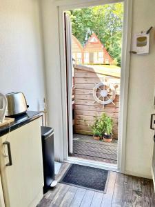 an open door leading to a patio with a garden at Chalet 95, Kingsdown Park in Deal