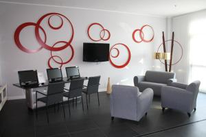 a living room with a table and chairs and red circles on the wall at Idea Hotel Milano Malpensa Airport in Case Nuove