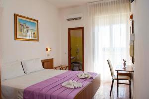 A bed or beds in a room at Hotel Sara*** Cesenatico