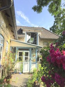 a house with a blue door and some flowers at Ferienwohnung "Wasserburg" in Ascheffel