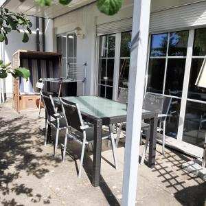 a glass table and chairs on a patio at Inselzauber in Breege