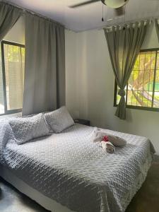 un dormitorio con una cama con un animal de peluche en Casa Savoirone Cabuya, en Cabuya