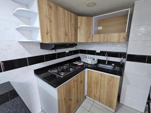 a small kitchen with a stove and a sink at Increíble Apartamento Familiar in Bogotá